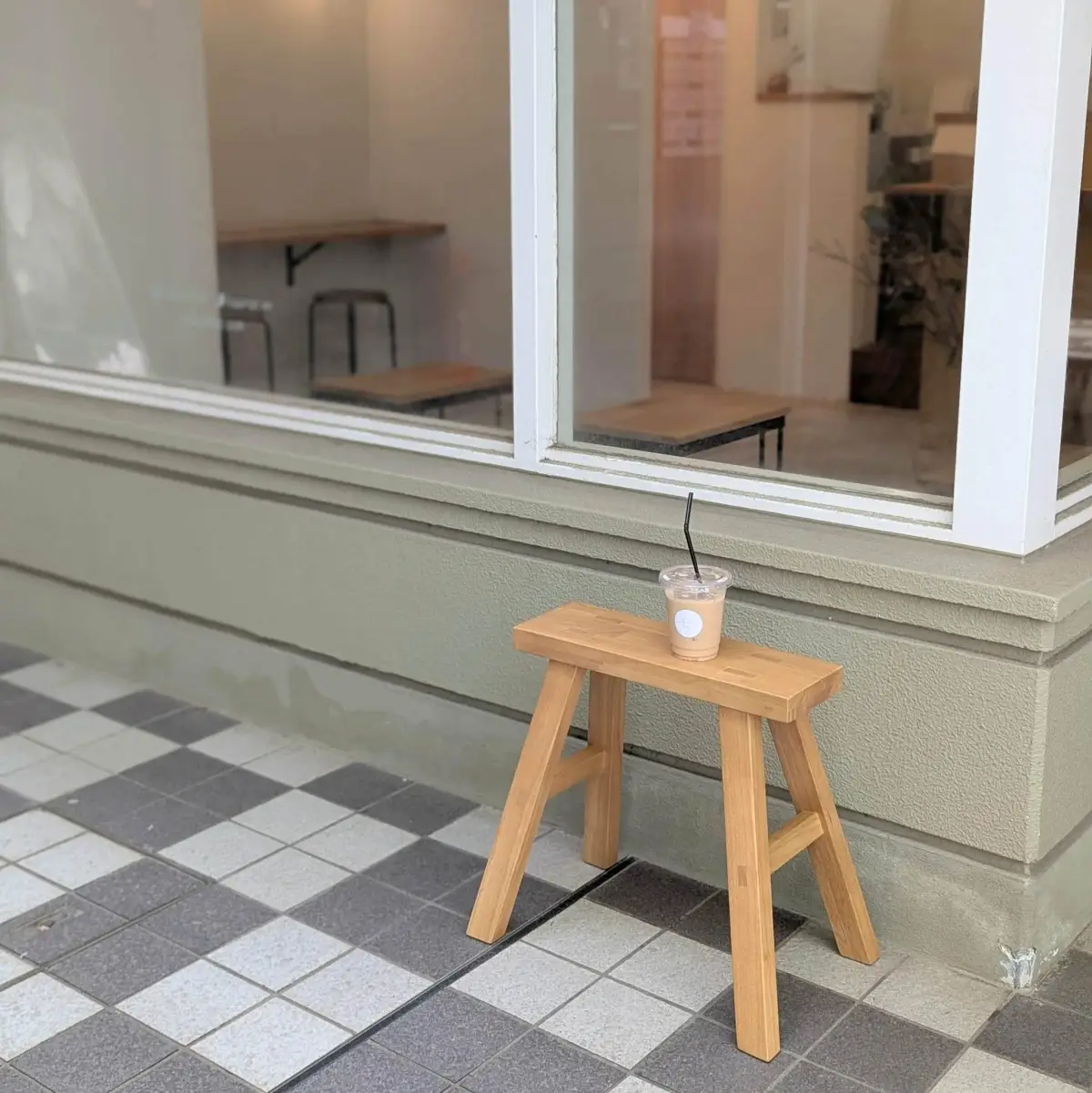 fuu coffeeの外観。窓辺のスツールにテイクアウトのアイスカフェラテが置かれている