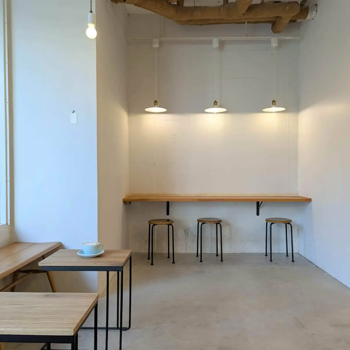 壁づけのカウンターとスツールが並ぶ店内の席